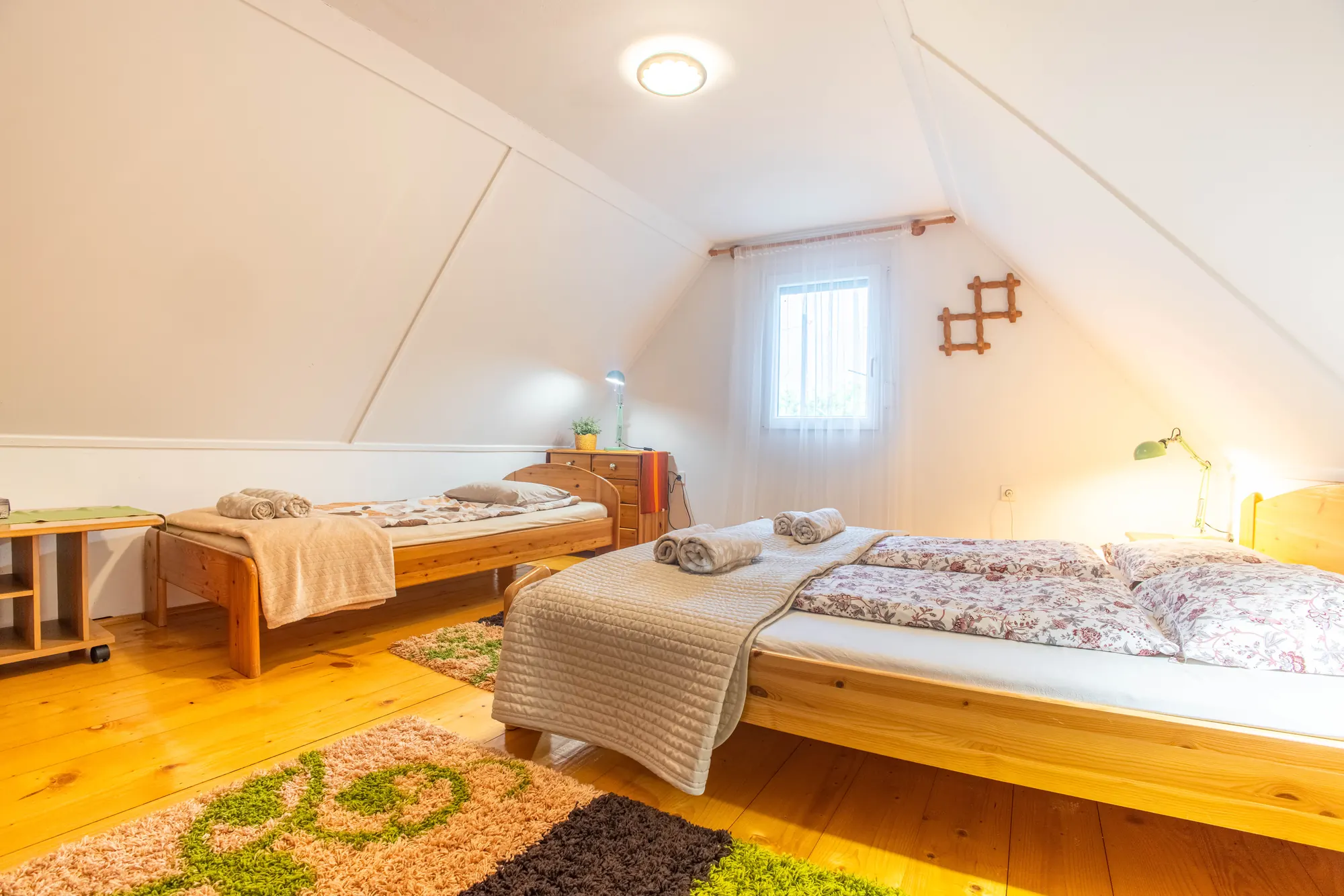 Tetőtéri hálótér fenyőfa ágyakkal